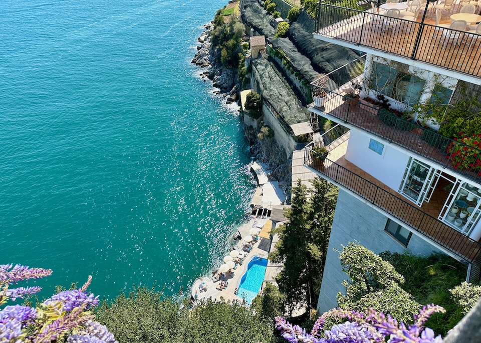 View looking down to the pool and beach from a clifftop terrace at Santa Caterina Hotel in Amalfi