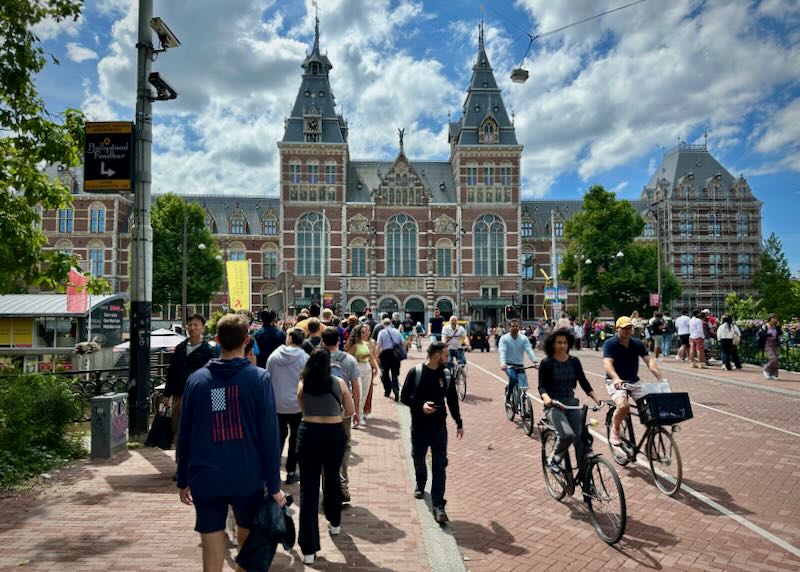 People ride bikes in front of the Rijksmuseum in Amsterdam