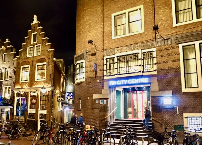entrance to a brick hotel building at night, with a row of bicycles in front