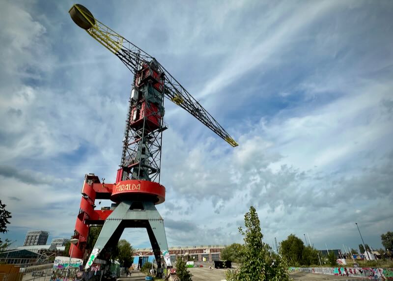 Colorful crane set against a blue sky with puffy white clouds