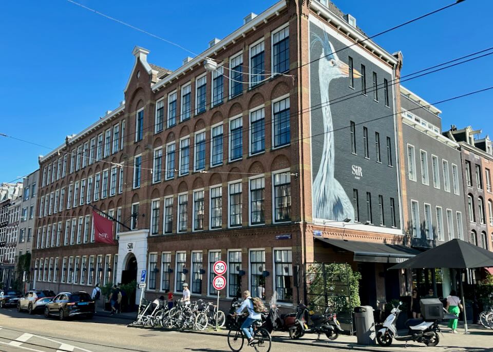 Large brick hotel building with a mural of a crane on one side