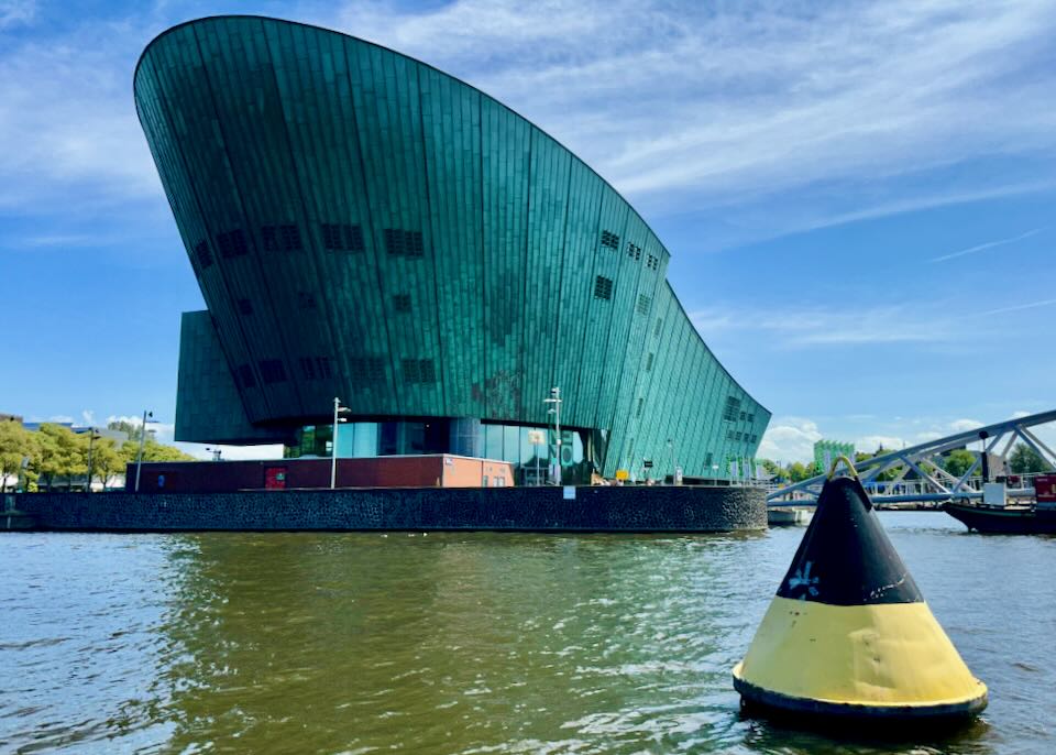 Science museum shaped like the hull of a ship, and sitting on the water
