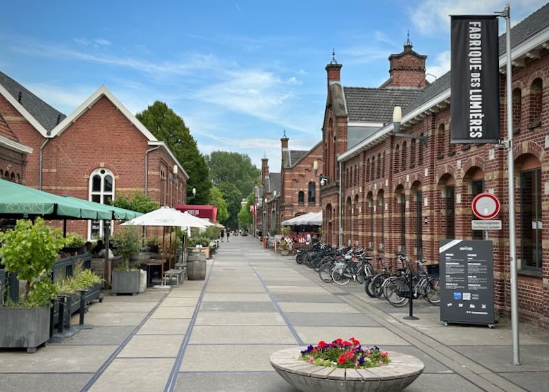Paved square lined with red brick buildings on a sunny day