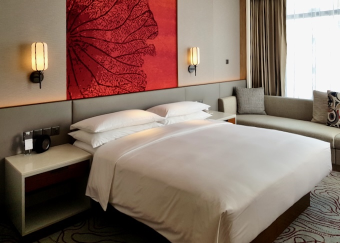 A bright red painting hangs above the hotel bed.