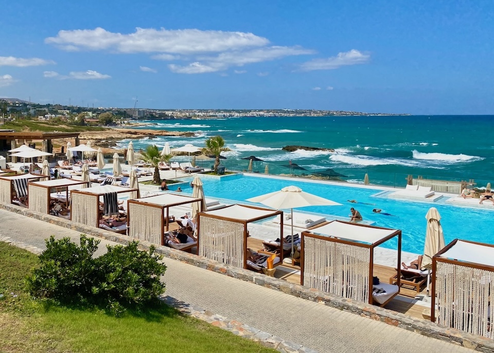 Bali beds decorated with sailing rope behind a large, sea-facing infinity pool at Abaton Island resort in Crete