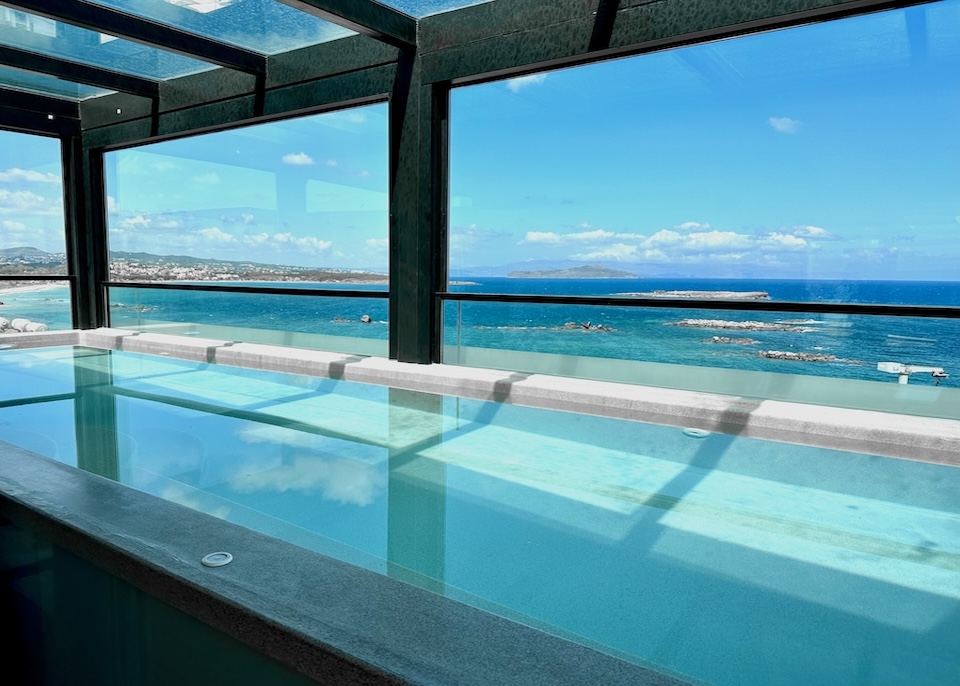 Glass-covered rooftop pool with a sea view at Chania Flair hotel in Crete