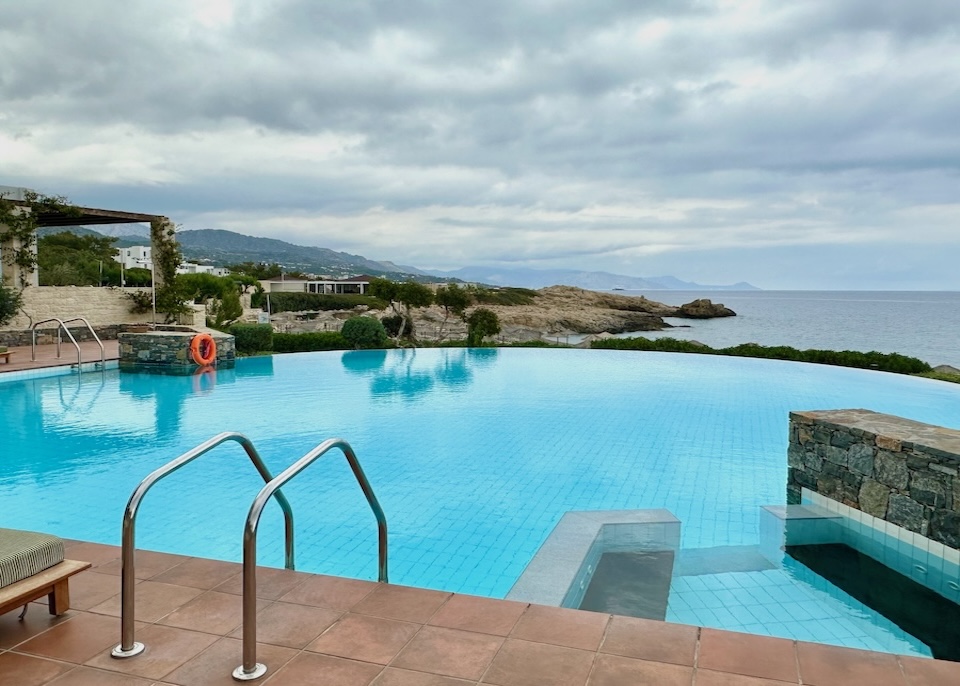 Half-circle infinity pool with attached jacuzzi overlooking the sea at Kakkos Beach resort in Crete