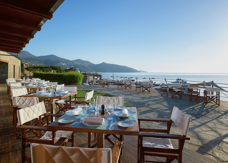 A sea-view, al fresco restaurant just before sunset at St Nicolas Bay resort in Crete