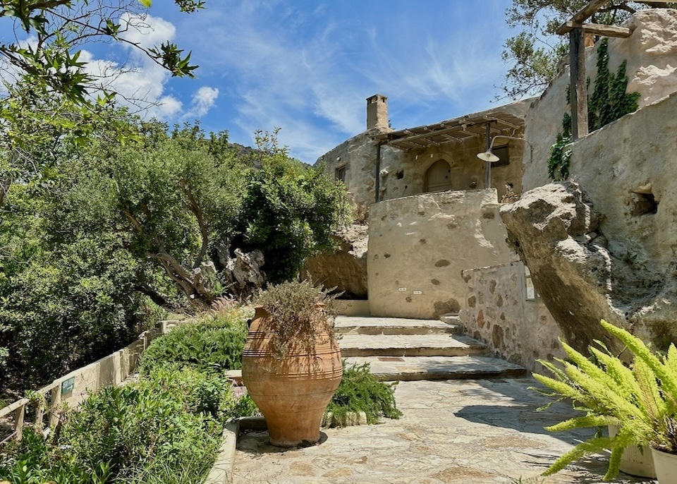 Rustic stone exterior and garden path at White River Cottages in Crete
