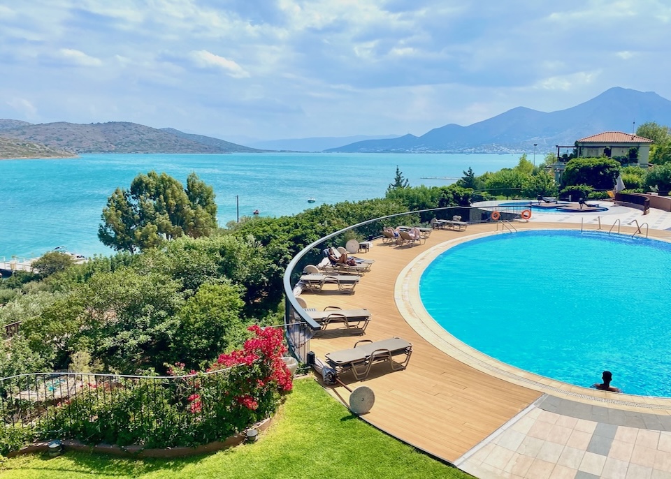 Circular pool set in a garden overlooking the sea at Domes of Elounda resort in Crete