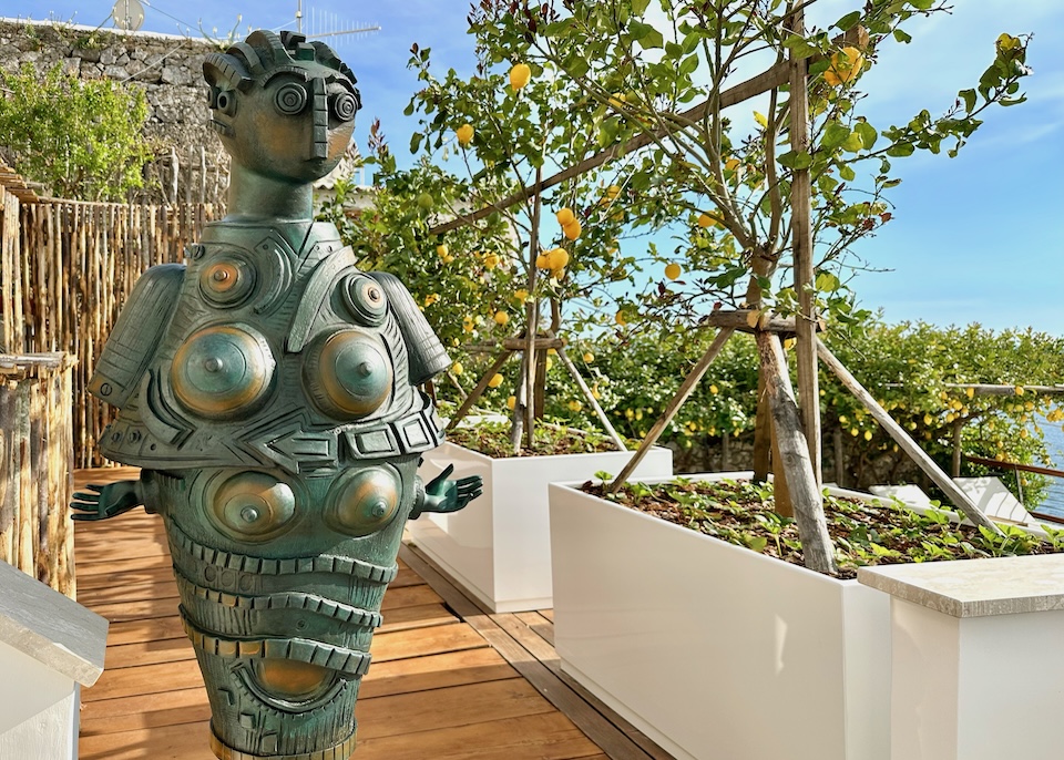 Bronze, avant-garde sculpture of a woman on a sea-view deck with lemon trees at Casa Angelina hotel in Praiano