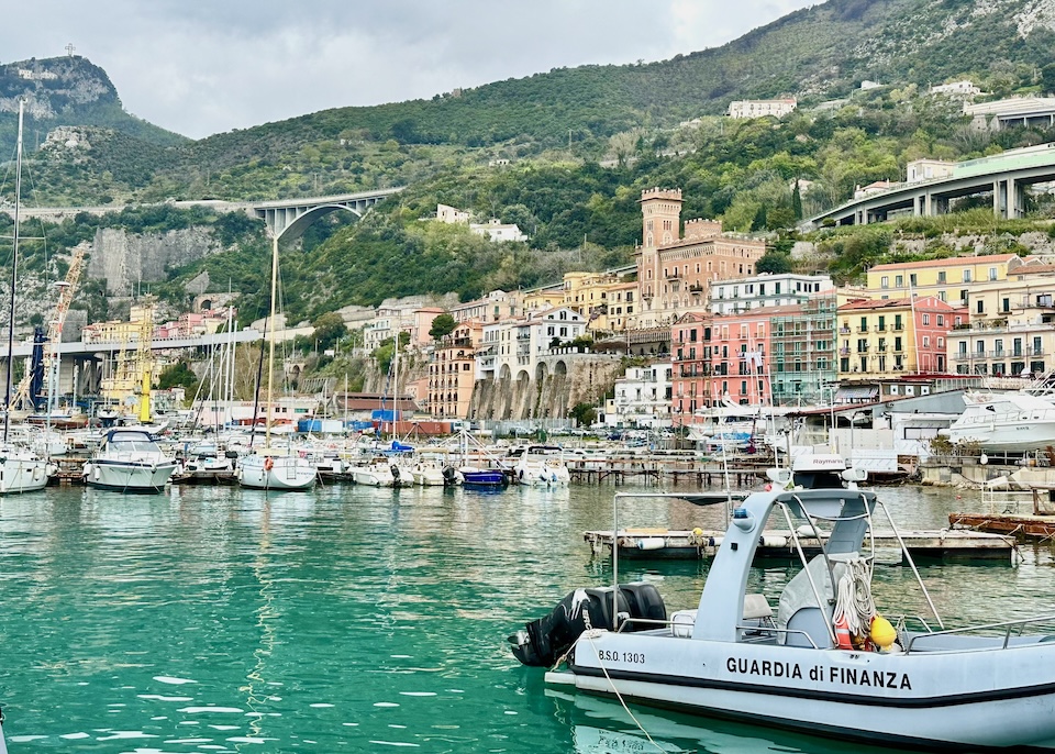 The port district of Salerno, with a busy marina of sailboats and colorful buildings on the shore