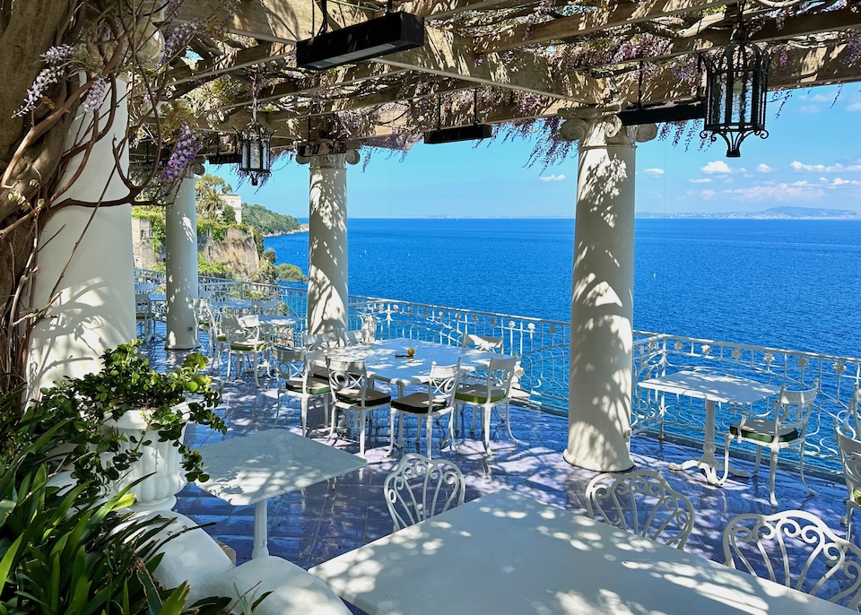 The wisteria-covered pergola and dining terrace above the sea at Bellevue Syrene hotel in Sorrento