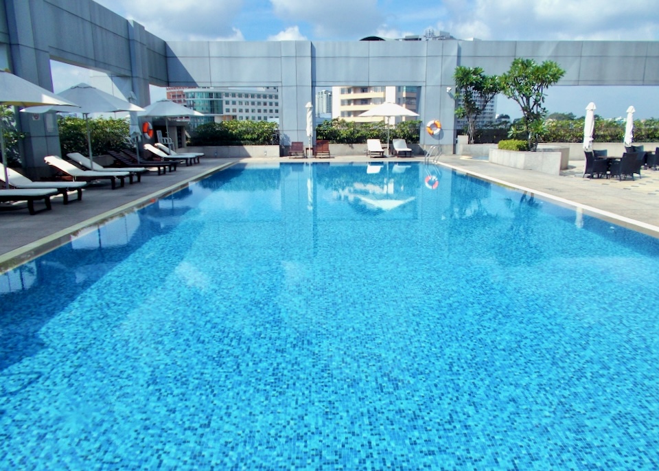 A large blue tiled pool sits on top of a tall building.