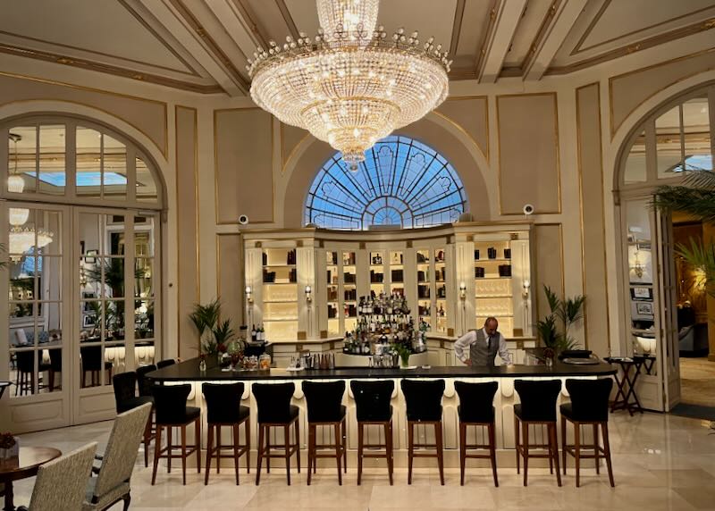 Opulent hotel bar with a crystal chandelier hung overhead
