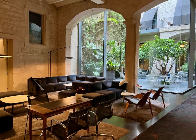 Sleek and sophisticated hotel lounge looking out to a garden courtyard.
