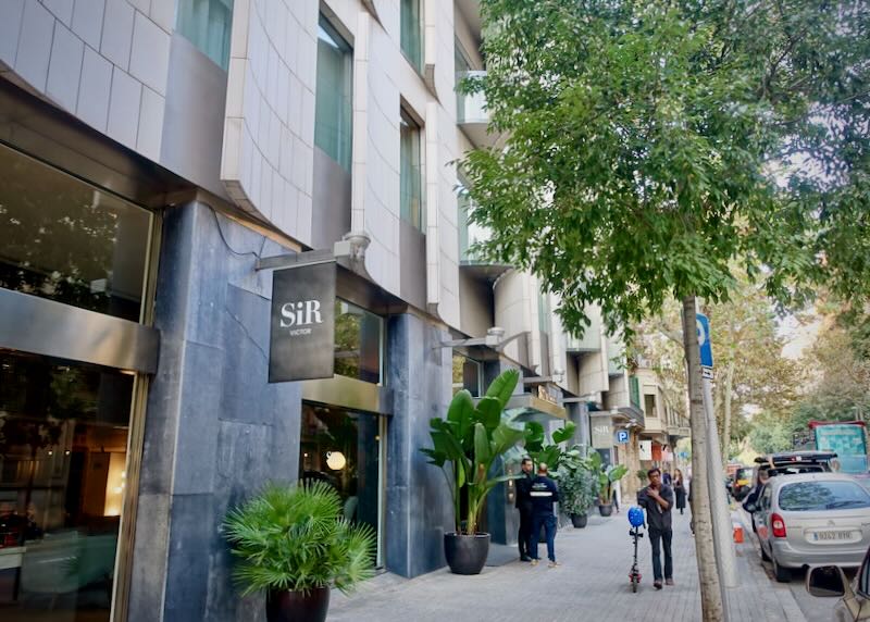 SIdewalk view of a Barcelona design hotel with pedestrians walking by