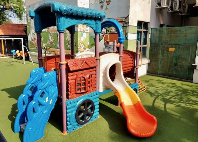 A colorful slide and playground equiptment.
