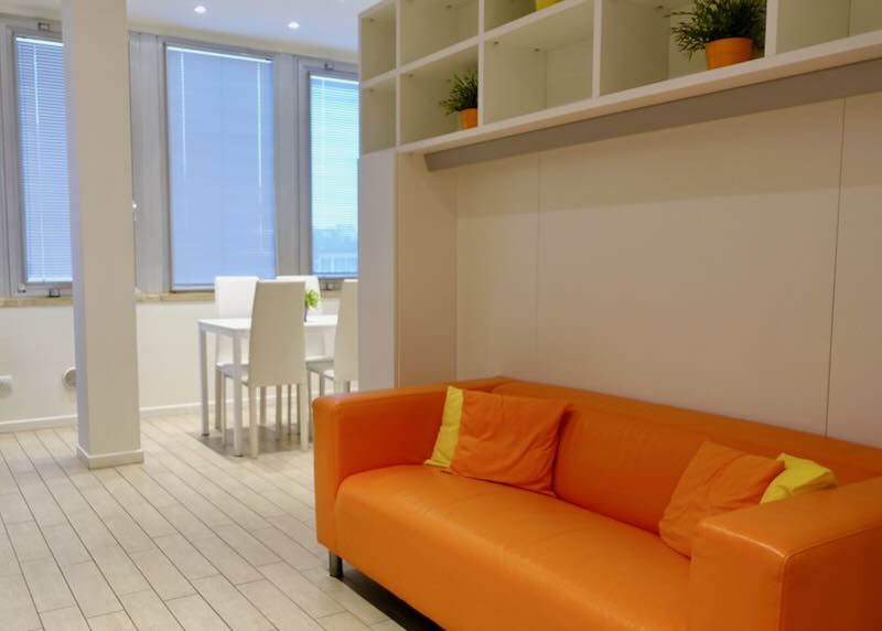 Airy white apartment with orange leather sofa