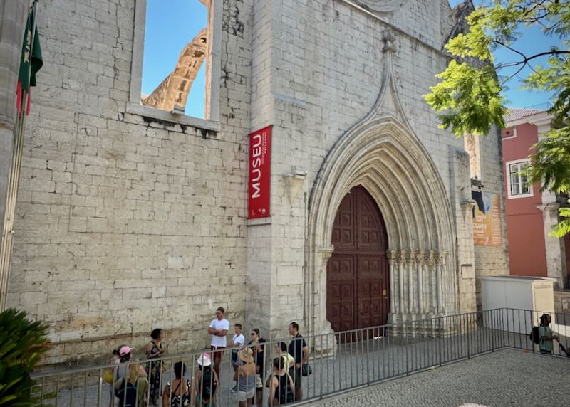 People wait outside the door of a ruined convent in Lisbon to get in