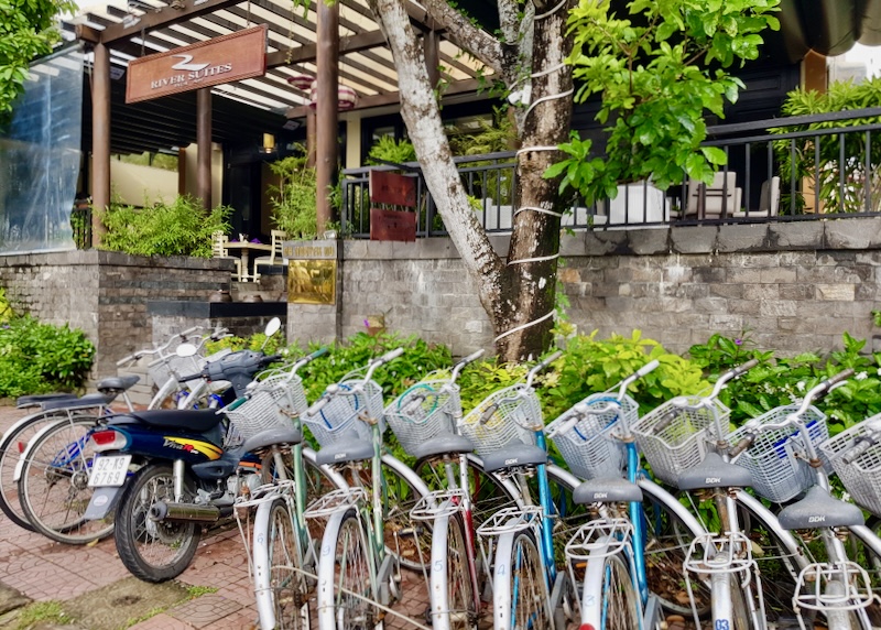 A row of bikes outside a hotel.