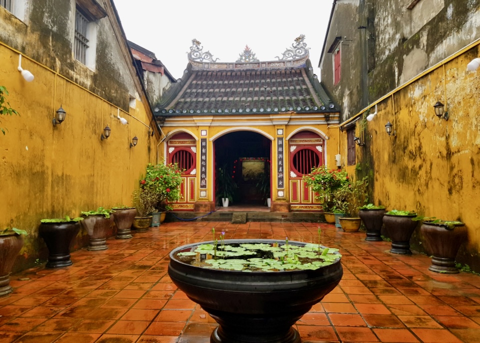 Yellow walls surround a small fountain with lily pads.