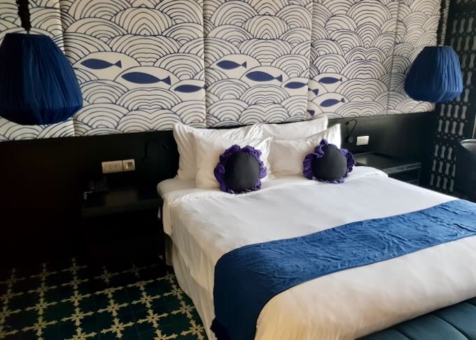 A hotel room with blue fish art on the wall.