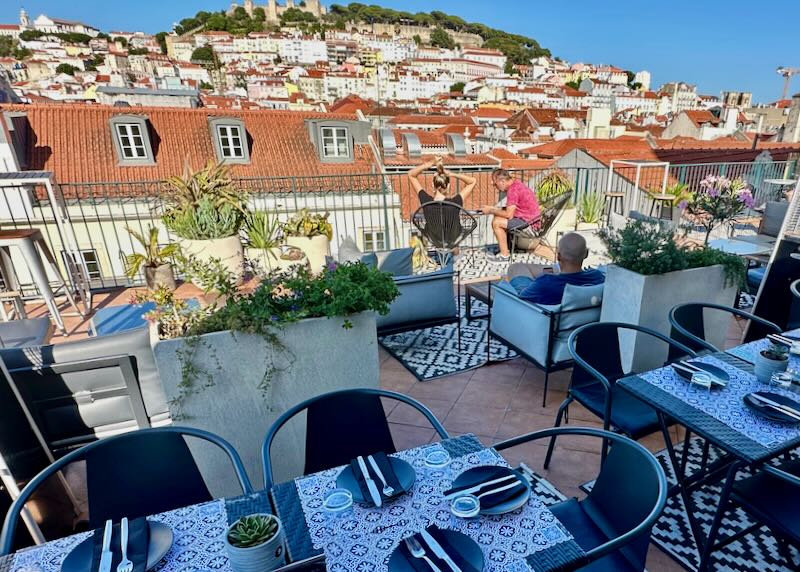 Rooftop terrace overlooking Lisbon, with cafe tables set for dinner