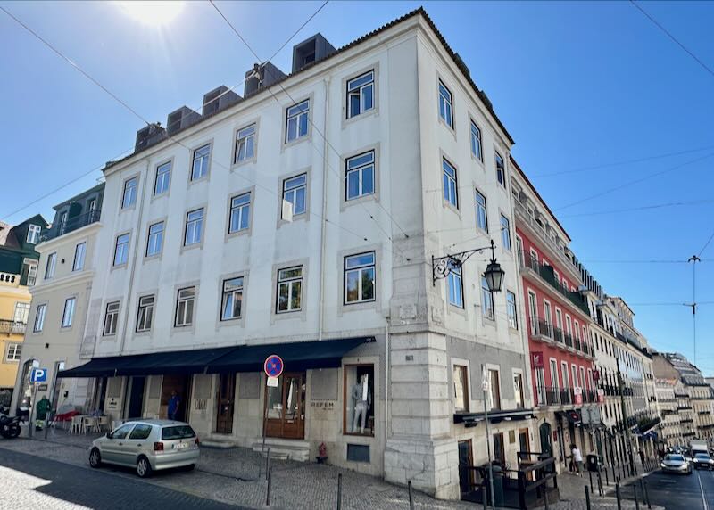 Exterior of a white historic hotel on a Lisbon streetcorner