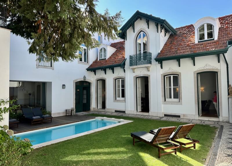 Small swimming pool in a grassy courtyard of a small rustic hotel