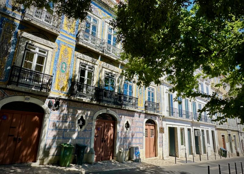 Historic building with colorful Turkish tile on a leafy street in Lisbon.