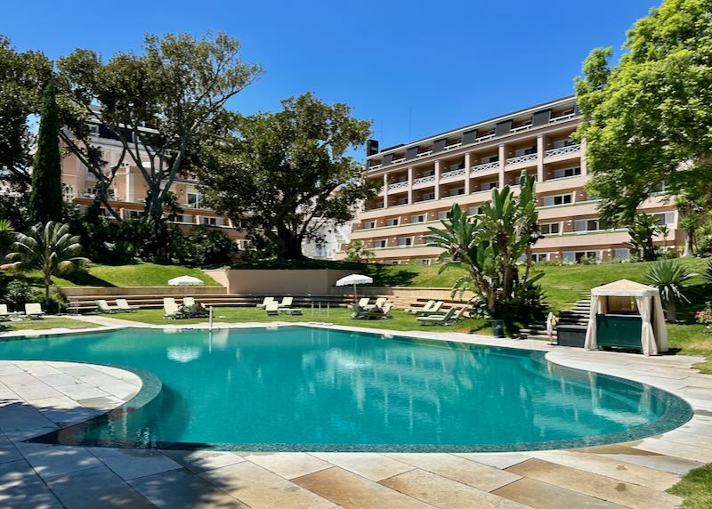 Outdoor hotel swimming pool set in manicured gardens