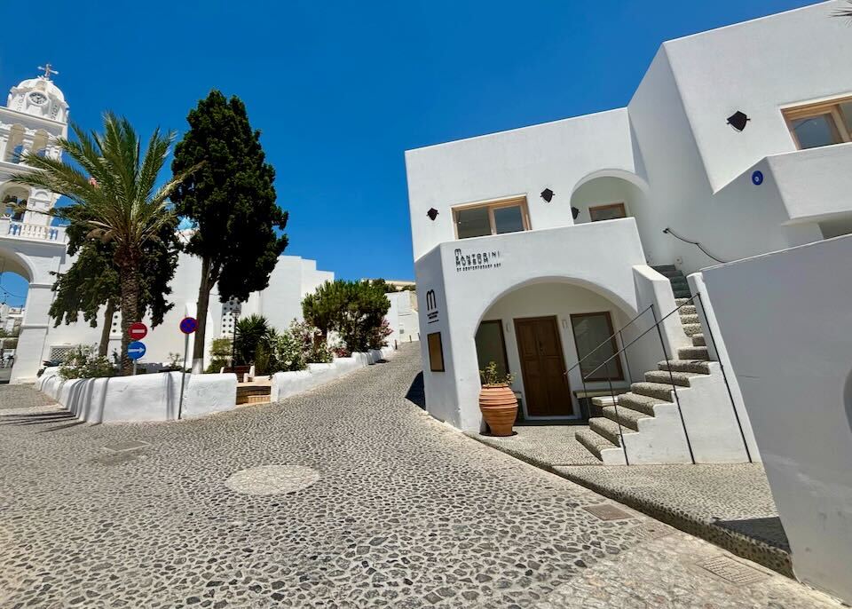 A white museum sits on a hill on Santorini.