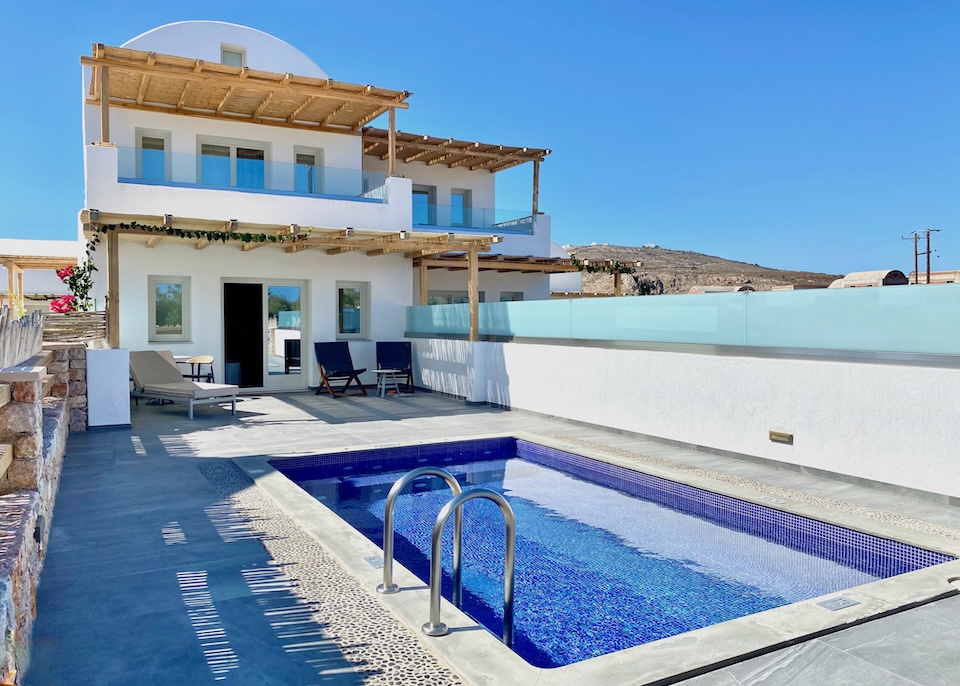 A two-story villa with a private pool, terrace, and pergola at a hotel in Santorini