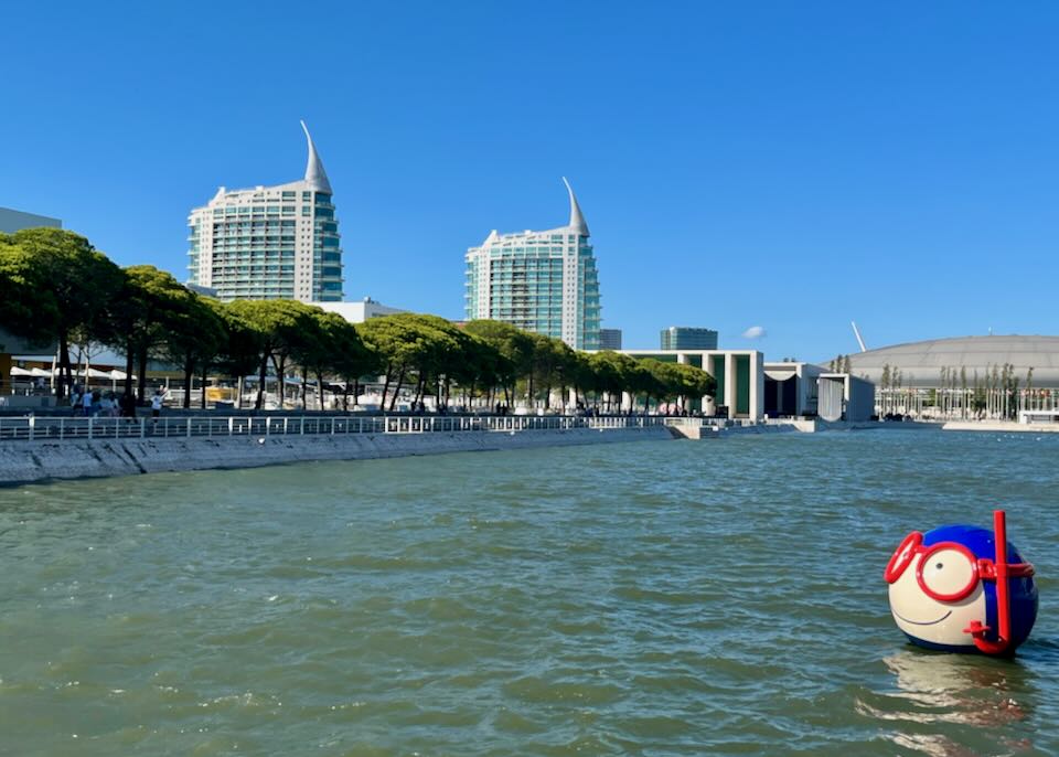 A cartoon-like floating head with goggles and snorkel floats in a bay in Lisbon.