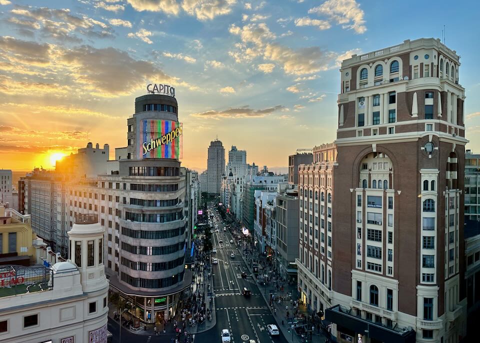 View of Madrid city skyline and iconic Schweppes sign at sunset