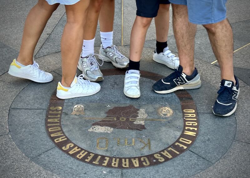 One family's feet posed for a photo on the KM 0 marker at Madrid's Puerta del Sol