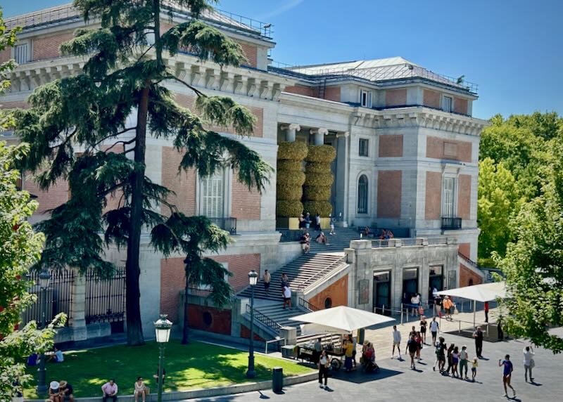 Photograph of the Prado Museum in Madrid on a sunny day, taken from a distance.