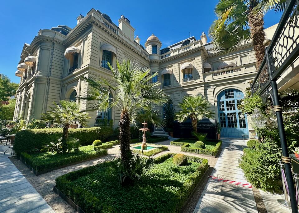 Beautifully manicured garden courtyard with palm trees at a Madrid hotel on a sunny day