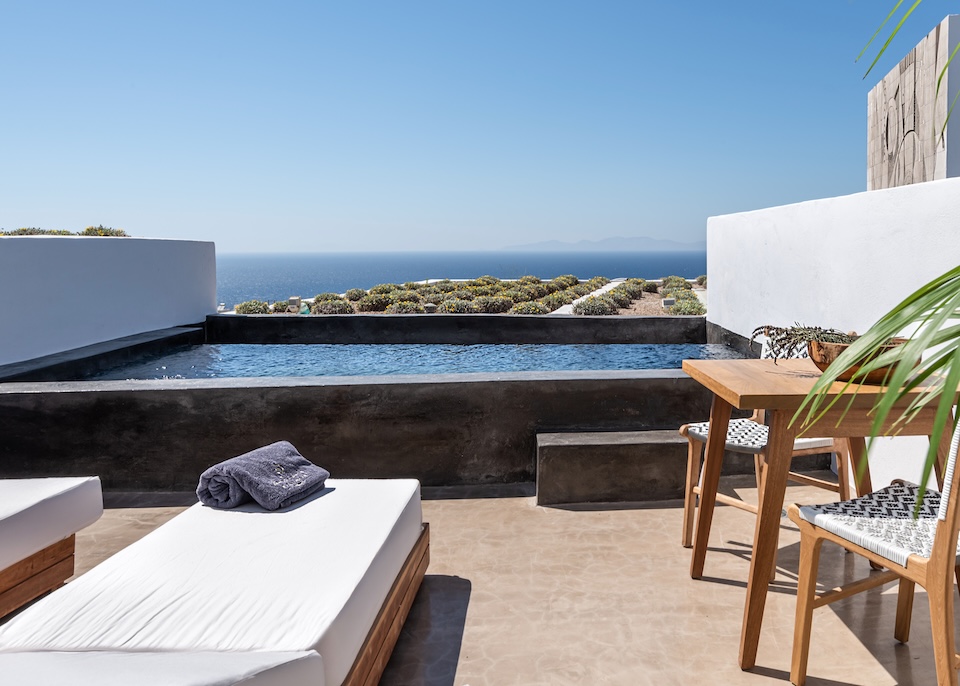 A private pool with a view over an orderly garden and the sea at Andronis Arcadia in Oia, Santorini.