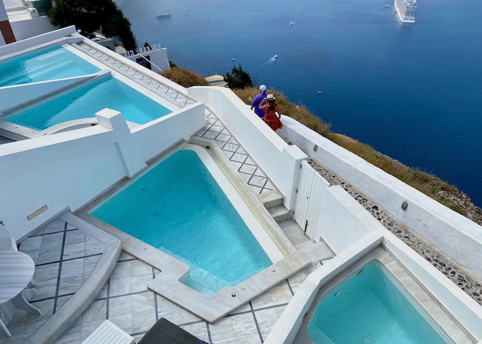 Four private plunge pools in different shapes all on marble terraces overlooking the caldera at Anteliz Suites in Firostefani.