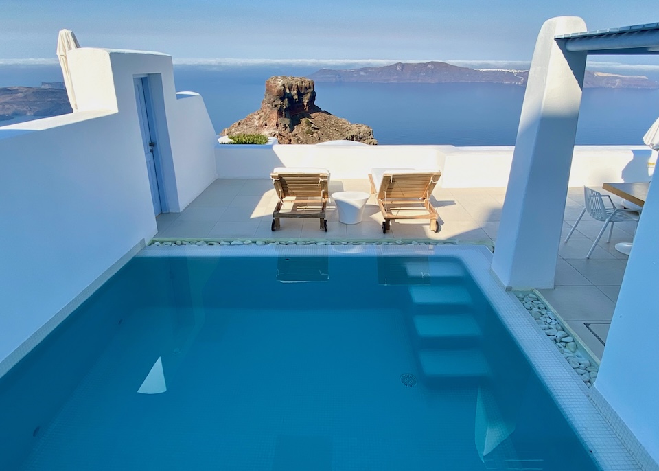 An amply sized private pool on a terrace with a pergola and view over the caldera and the top of Skaros Rock at Astra Suites in Imerovigli, Santorini.