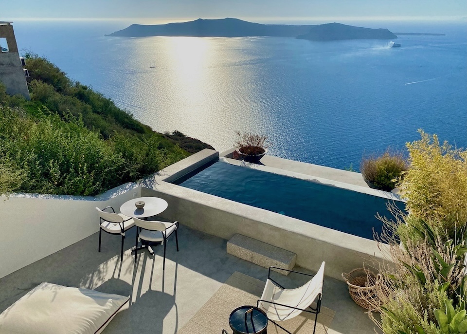 Almpst sunset from a private infinity pool above the caldera facing Thirassia Island at Atoles Retreat in Imerovigli, Santorini.