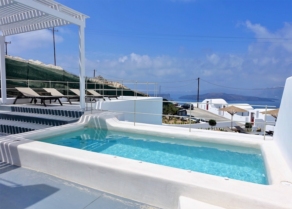 A private plunge pool with a view toward the caldera in the distance at Cape 9 Exclusive Villas and Suites in Akrotiri, Santorini.