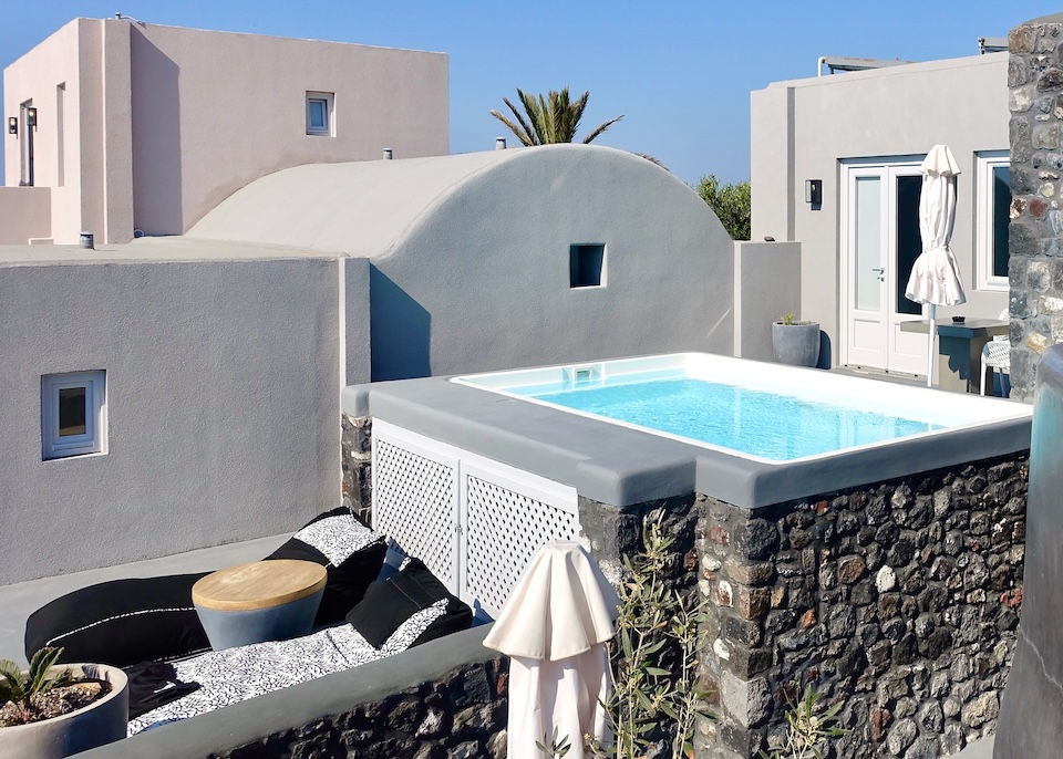 An elevated private plunge pool on a patio behind a villa at Elysian hotel in Finikia, Santorini.