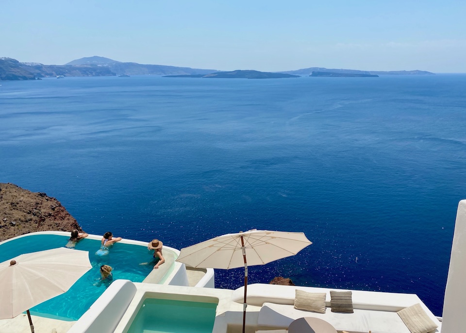 A private plunge pool sits on a balcony above the hotel's main pool with a view of the caldera at Armenaki hotel in Oia, Santorini.
