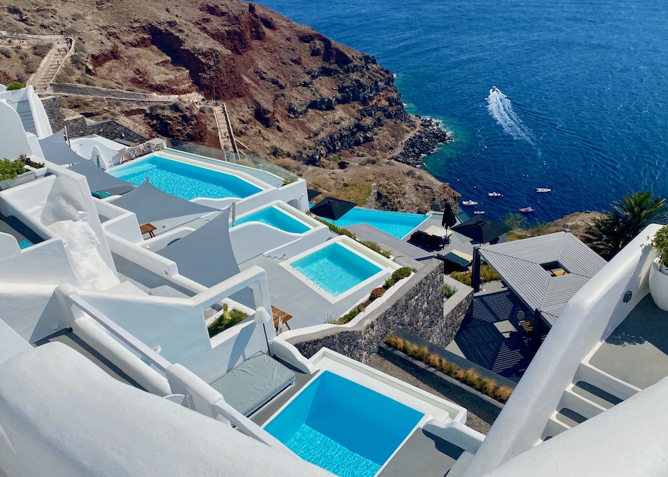 A series of private pools, all different shapes and sizes, leads down the cliffside to the caldera and sea at Charisma Suites in Oia, Santorini.