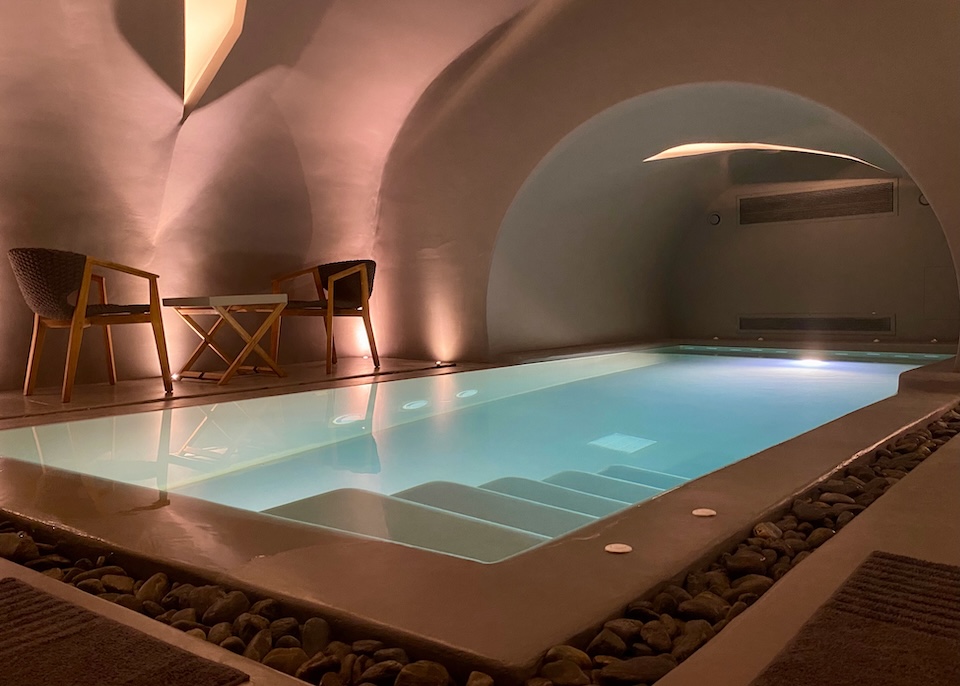 A large, softly lit indoor cave pool at Kivotos Hotel in Imerovigli, Santorini.