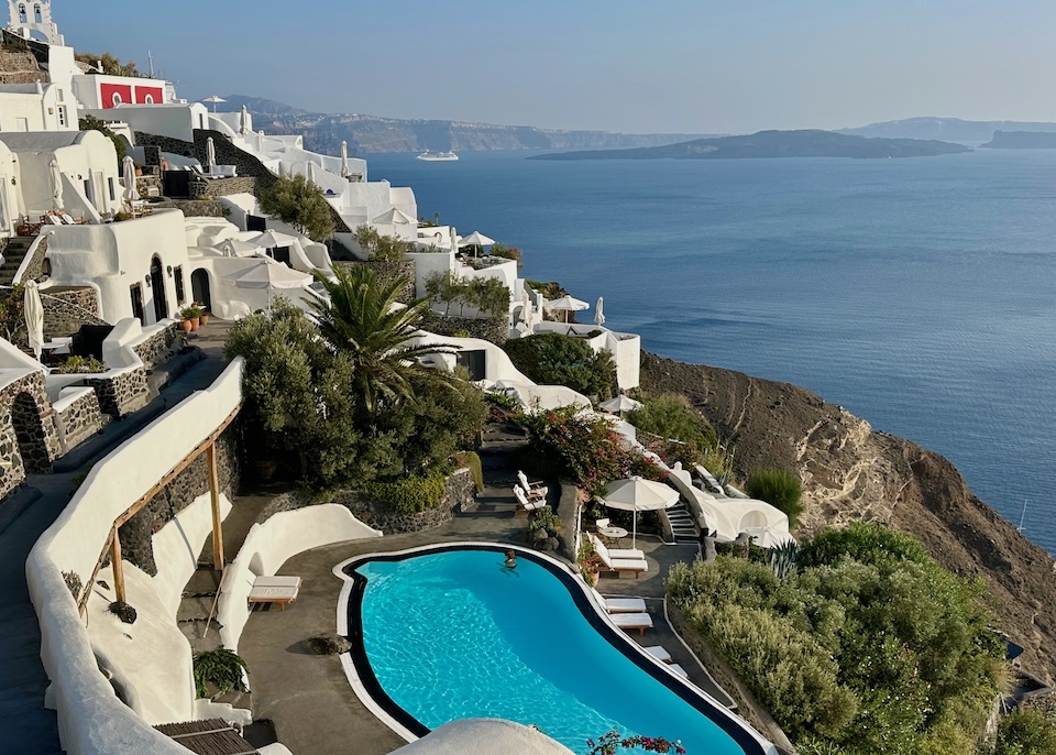 An infinity pool outlined in bold black and white on a terrace overlooking the caldera at Perivolas hotel in Oia, Santorini.