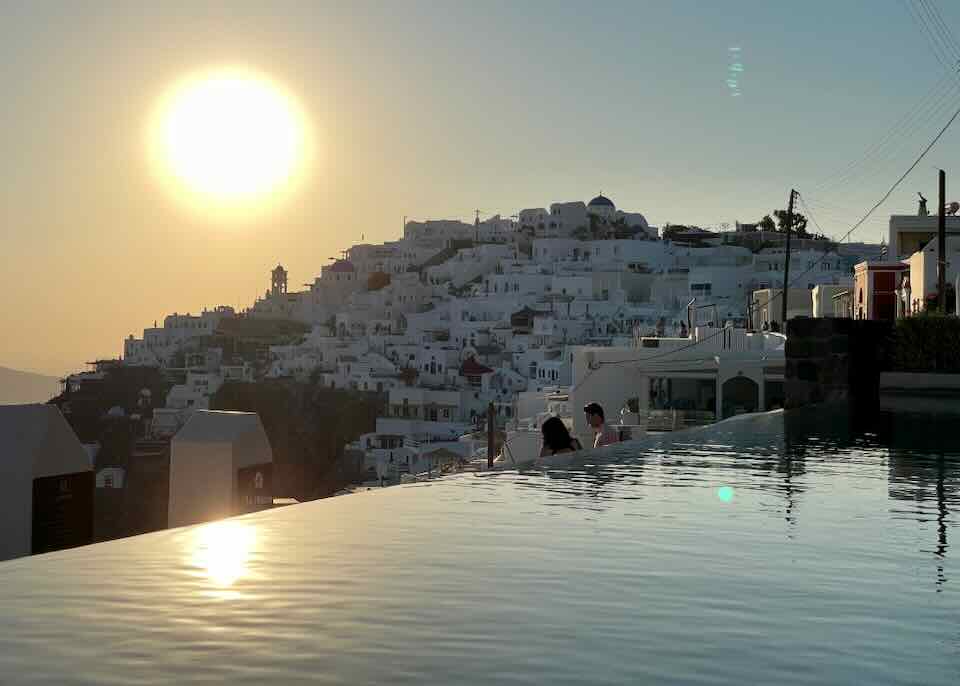 Infinity pool with sunset view in Santorini.
